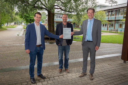 Landrat Stefan Frey (l.) und IT-Leiter Thomas Eberhard (r.) nehmen die Zertifizierungs-Urkunde von Franz Obermayer von der complimant AG entgegen.