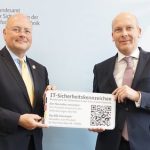 BSI-Präsident Arne Schönbohm (l.) überreicht eines der IT-Sicherheitskennzeichen an LANCOM CTO Christian Schallenberg.