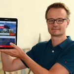 Projektleiter Mathias Keller zeigt auf einem Tablet die Startseite der überarbeiteten Homepage kreis-soest.de.