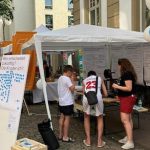 Offenbacherinnen und Offenbacher notieren am Stand auf dem Mainuferfest auf Plakaten