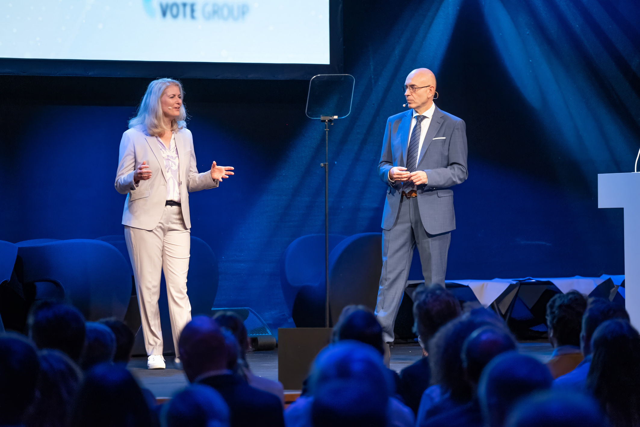 Das Bild zeigt die AKDB-Vorstände Gudrun Aschenbrenner und Rudolf Schleyer auf der Bühne des AKDB Kommunalforums.