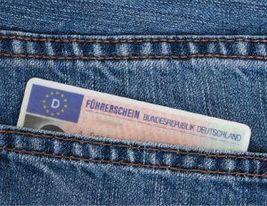 Ein deutscher Führerschein im Scheckkartenformat ragt zum Teil aus der der Hosen- oder Gesäßtasche einer Jeans.