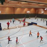 In einer Turnhalle spielen Kinder Fußball