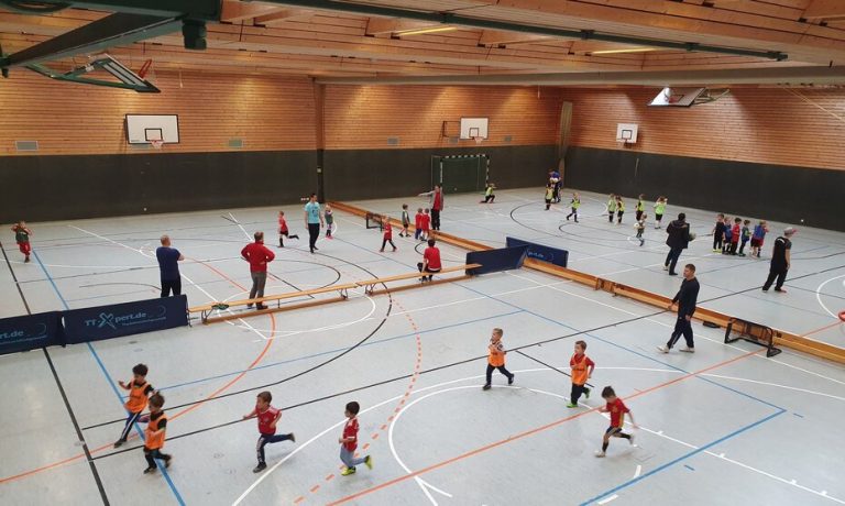 In einer Turnhalle spielen Kinder Fußball