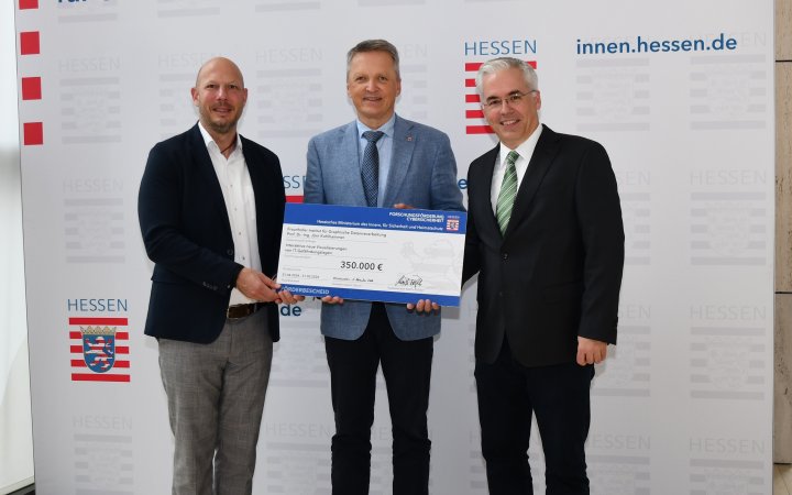 Von links halten Bastian Schäfer von der ekom21, Staatssekretär Martin Rößler und Prof. Dr.-Ing. Jörn Kohlhammer vom Fraunhofer IGD den Förderbescheid des Landes Hessen.