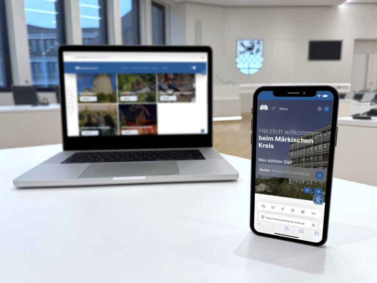 Auf einem Laptop und einem Mobiltelefon wird die neue Website des Märkischen Kreises gezeigt.