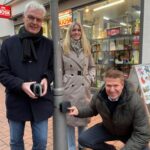 v.l.: Albrecht Pförtner, Christina Junkerkalefeld und Carsten Schlepphorst stehen bei einer Passantenzählstelle an einem Pfosten in der Gütersloher Innenstadt, im Hintergrund ist das Schaufenster eines Geschäfts zu sehen.