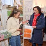 Zwei Frauen stehen in einer Boutique und unterhalten sich.