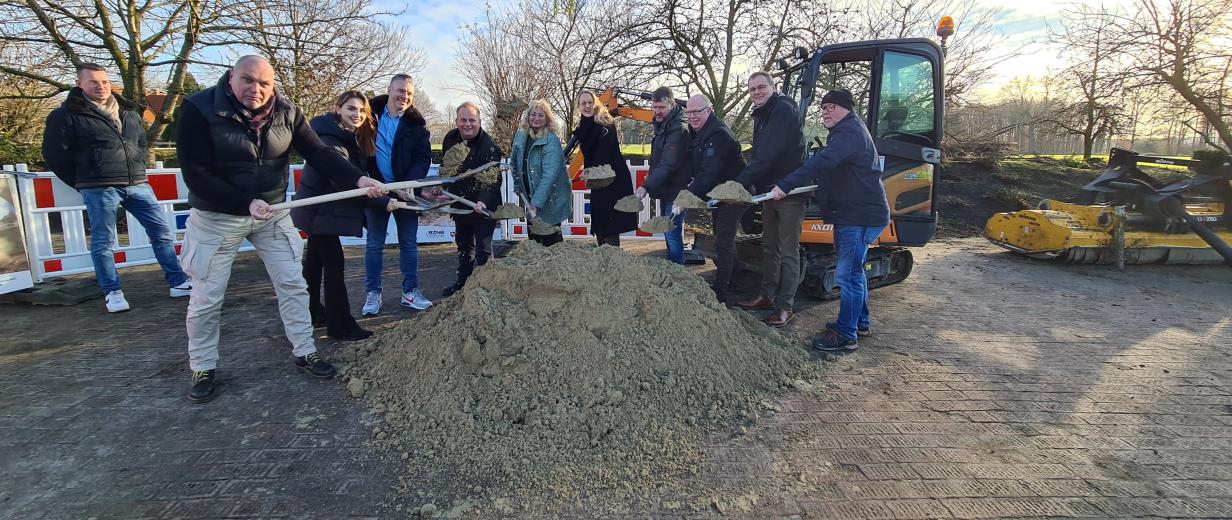 v.l.: Tiemo Papsdorf, Baufirma Kuhlmann; Thomas Barufke und Jessica Rotärmel, Stabsstelle Breitband, Landkreis Osnabrück; Mario Aquino, Netzbetreiber GVG Glasfaser; Dominik Schmidt, Baufirma Kuhlmann; Claudia Pelzl, Netzbetreiber GVG Glasfaser; Landrätin Anna Kebschull; Marco Kreyenhagen, Hof Kreyenhagen; Bürgermeister Erik Ballmeyer, Ostercappeln; Stephan Simon, Stabsstelle Breitband, Landkreis Osnabrück. Sie halten Schaufeln in der Hand und werfen damit Aushubmaterial, das zu einem Berg aufgehäuft zwischen ihnen liegt, in die Luft. Im Hintergrund ist ein kleiner Bagger zu sehen.