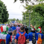 Fans strömen in ein Fußballstadion.