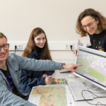 Präsentation der GeoSN-SchulApp auf einem Desktopbildschirm durch Lukas Garte und Jacqueline Seifert, beide von Esri und Claudia Gedrange vom GeoSN.